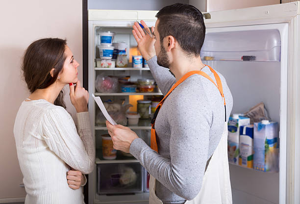 Professional workman visiting housewife customer for after-sales service of refrigerator